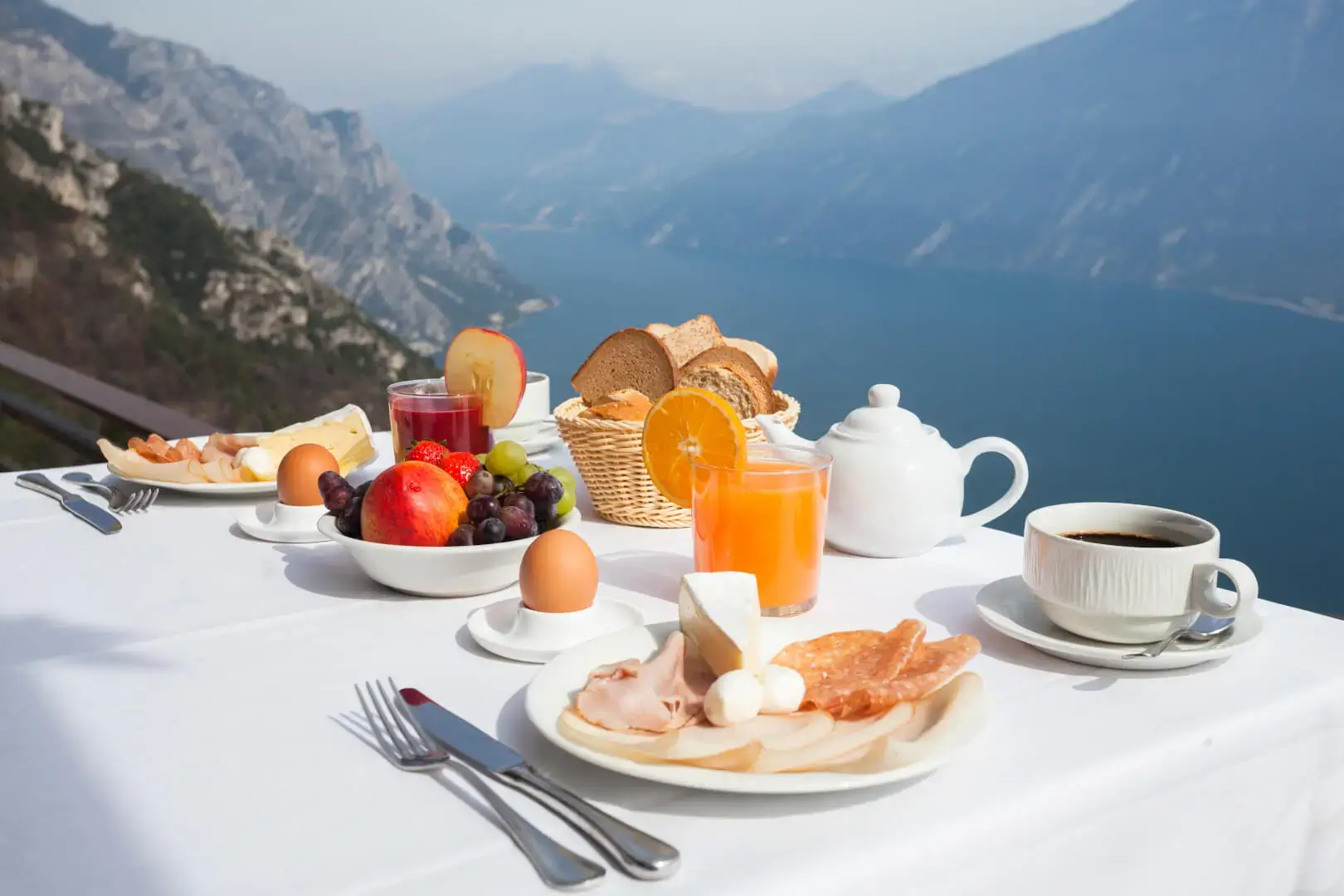 Colazione all'aperto con vista lago e montagne.