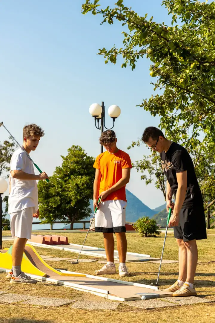 Giovani che giocano a minigolf all'aperto.