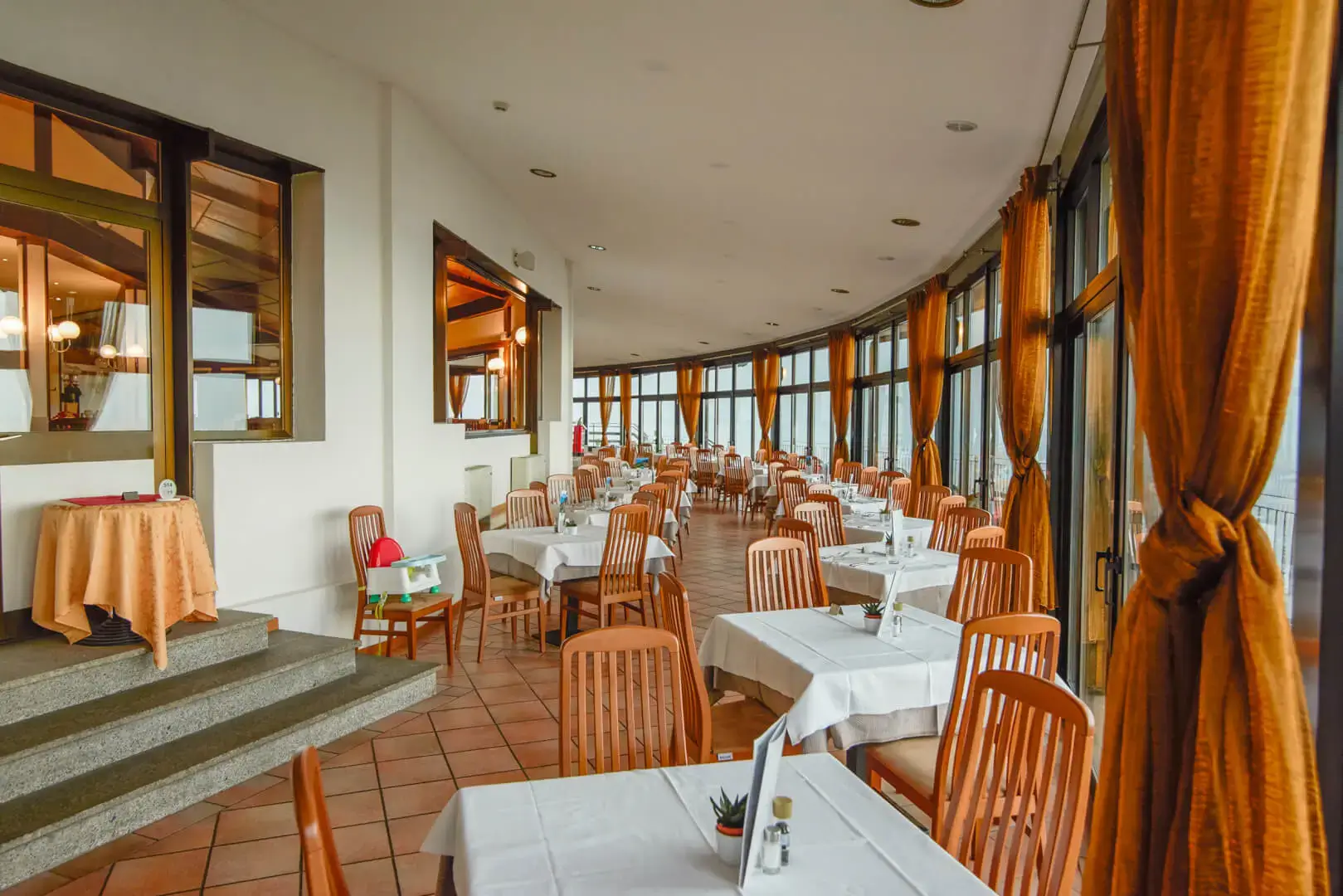 Ristorante elegante con tavoli imbanditi e grandi finestre.