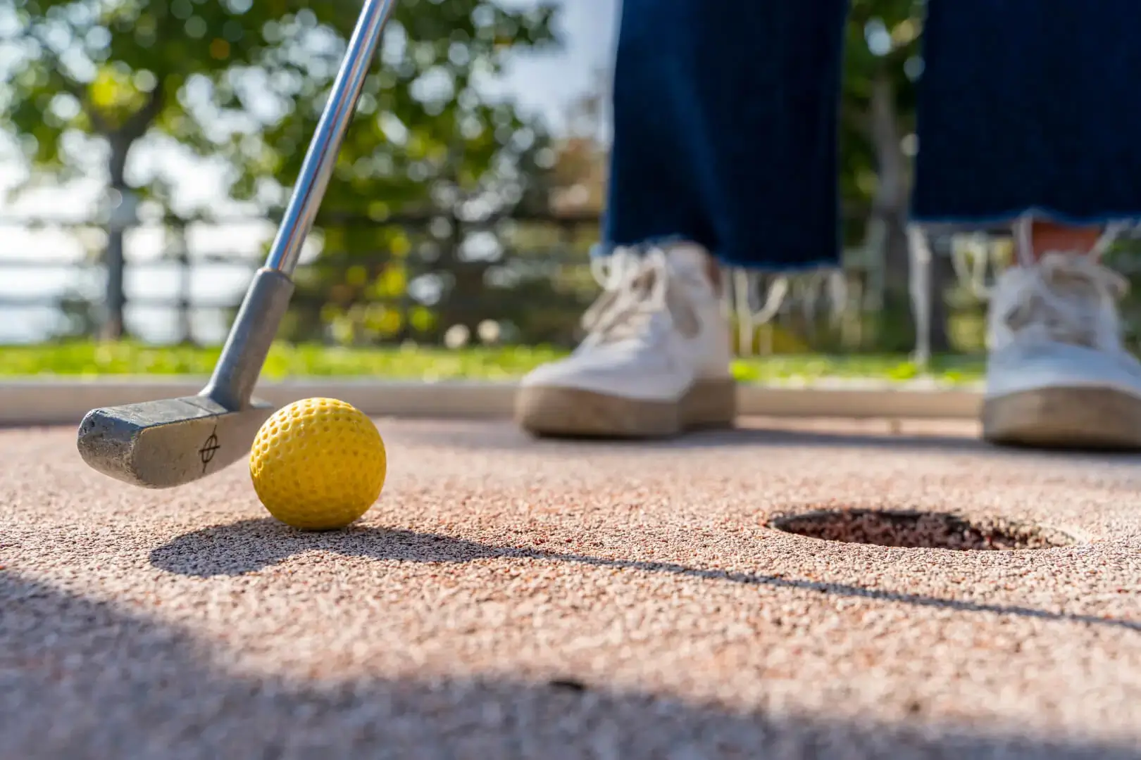 Giocatore di minigolf sta per colpire la palla.