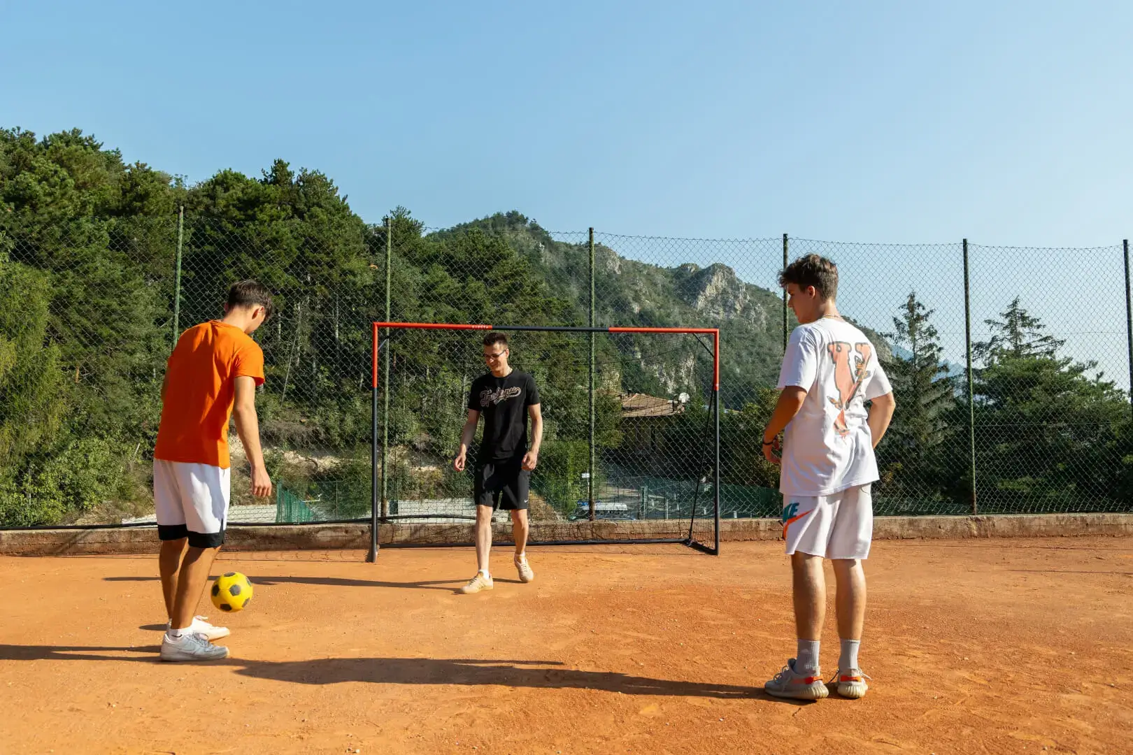 Giovani che giocano a calcio-tennis all'aperto.