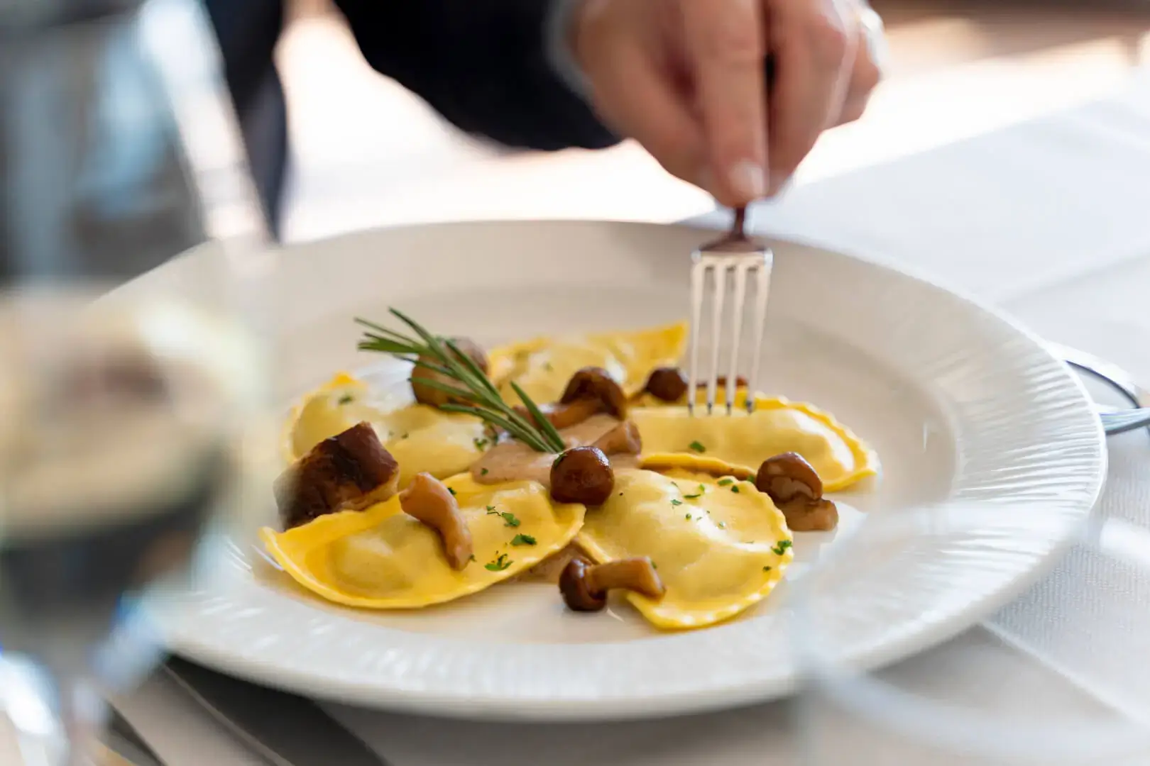 Persona mangia ravioli ai funghi.