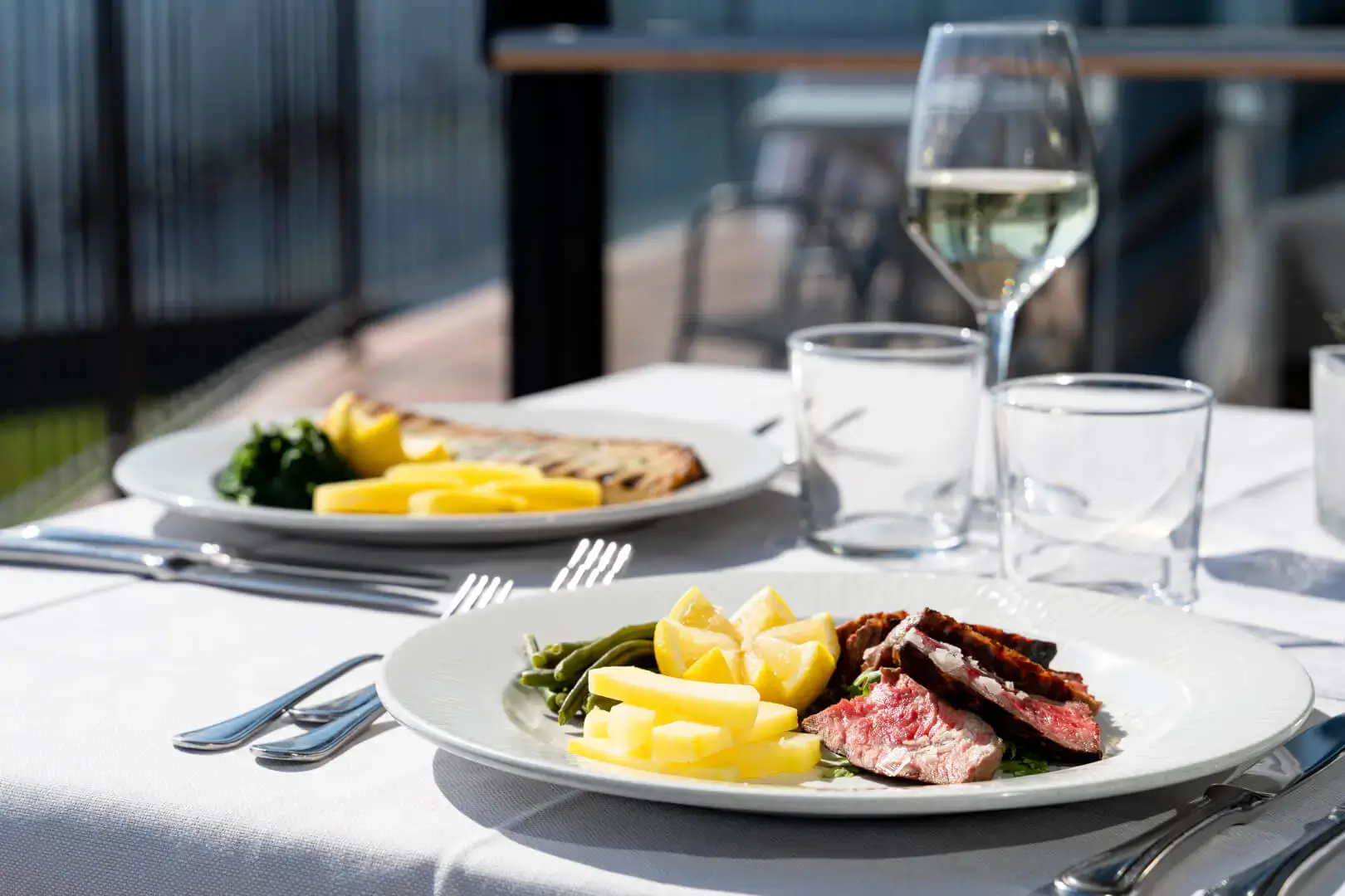Cena elegante all'aperto con vino bianco.